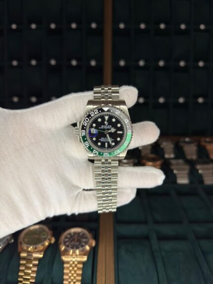 Iconic Rolex GMT-Master II 40mm with black dial and green-black bezel, complete with original box and authentication documents.